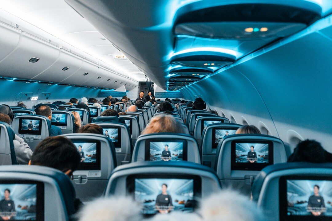 People flying in a blue tinted airplane.