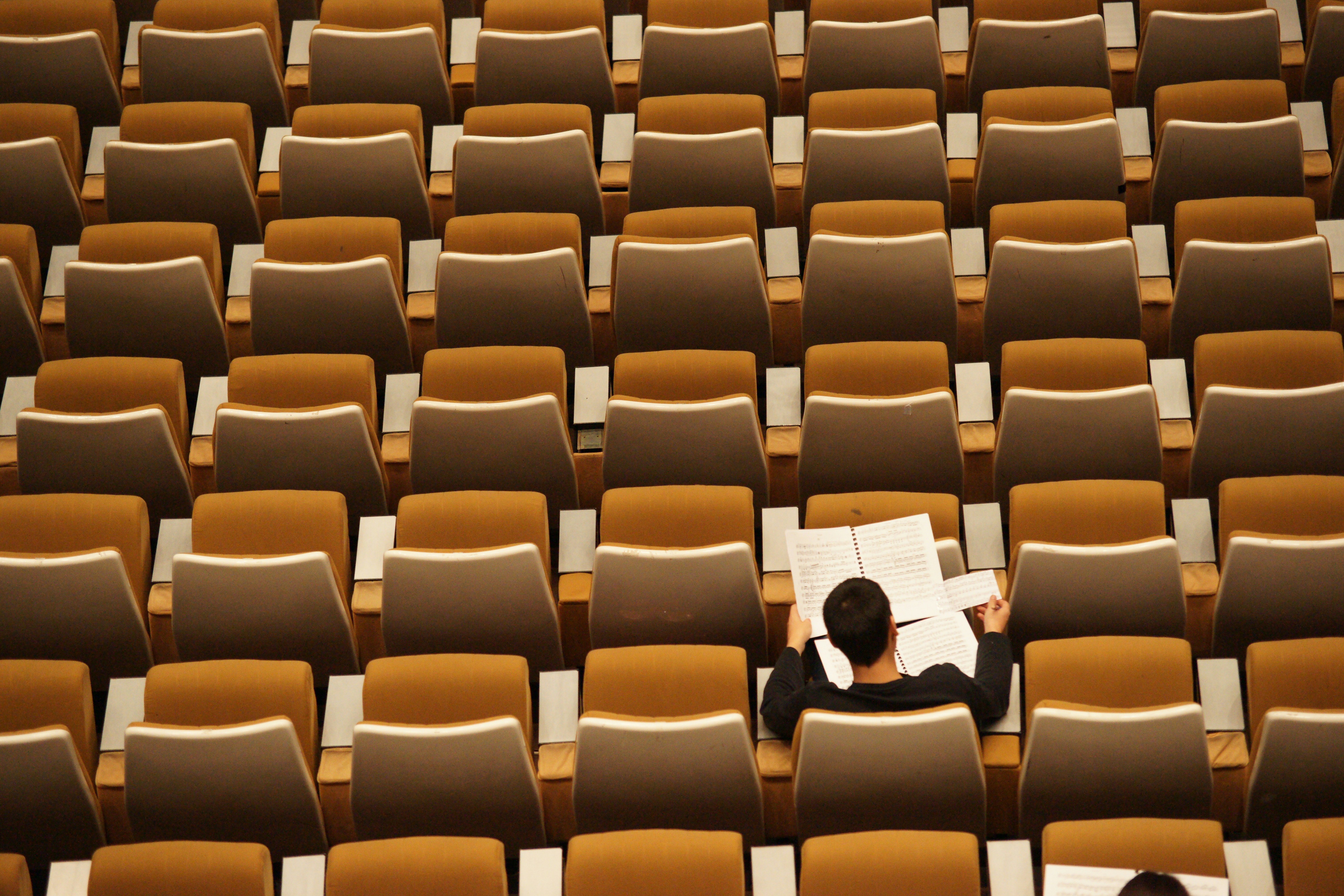 A top down photograph of a man studying inside a college classroom.